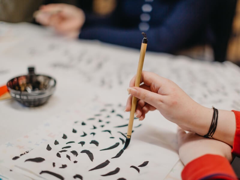 A close up of a hand holding a calligraphy brush in the process of calligraphy